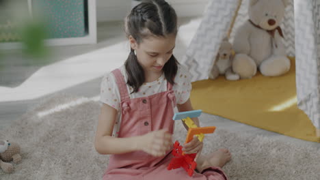 girl playing with building blocks in playroom
