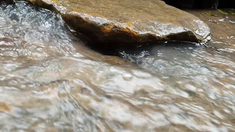 flowing mountain spring water stream running down huge sandstone slabs of rock, crystal clear drinking water, meditation tranquil and peaceful calming outdoor nature scene footage