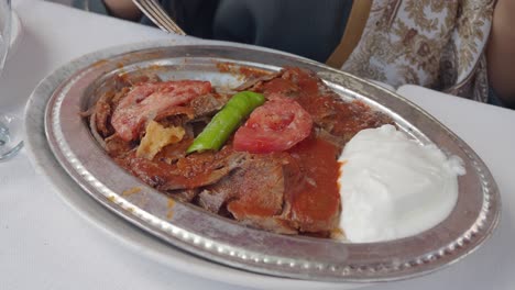 enjoying a plate of iskender kebab