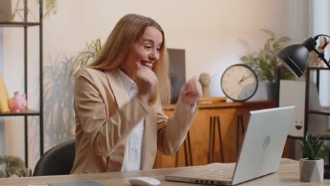 Geschäftsfrau-Gewinnerin,-Die-Im-Büro-Surft-Und-Auf-Dem-Laptop-Tippt,-Feiert-Großen-Lottogewinn-Und-Gute-Nachrichten