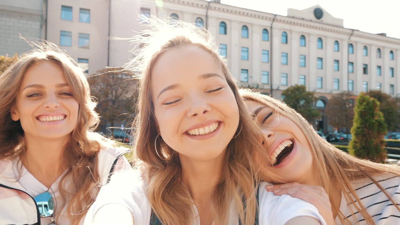 세 명의 행복한 친구들이 야외에서 셀피를 찍고 있습니다.