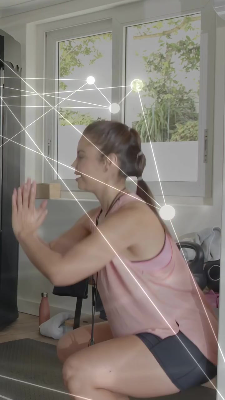 Vertical video: Woman raising arms, starting squats in gym, net overlay tracking motion for fitness