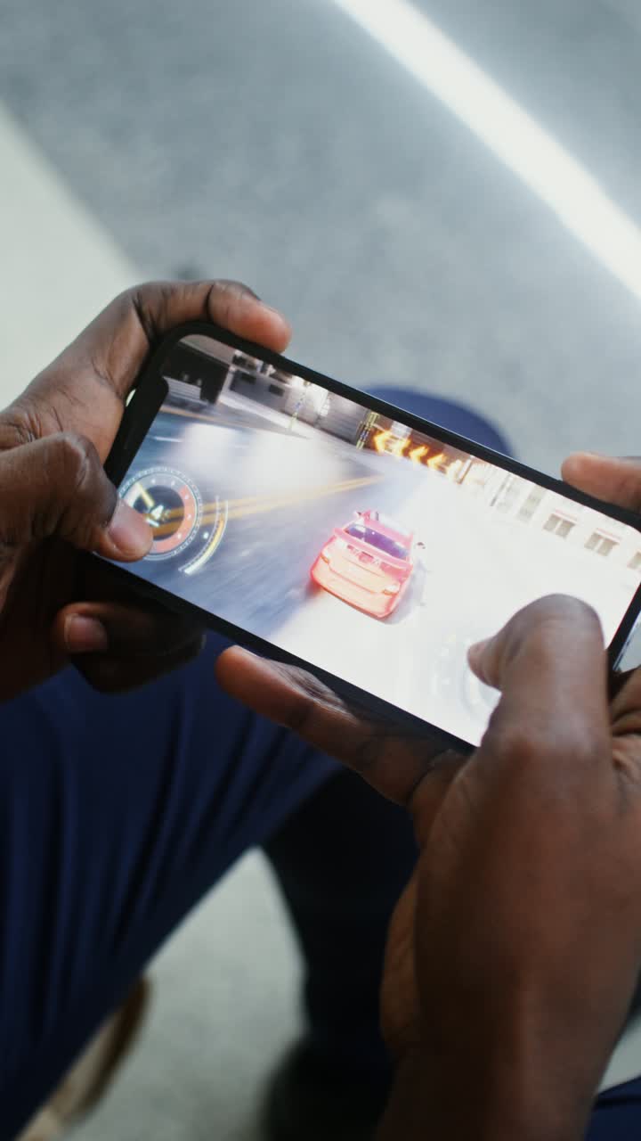 Person playing car racing game on smartphone