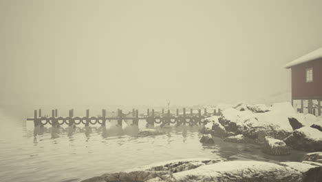 un día de invierno con niebla en la cabaña roja junto al mar