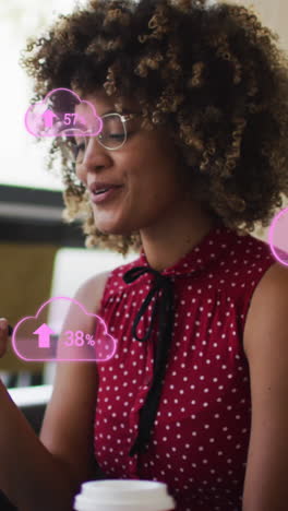 animación de iconos de nubes sobre una mujer de negocios afroamericana que usa un teléfono inteligente