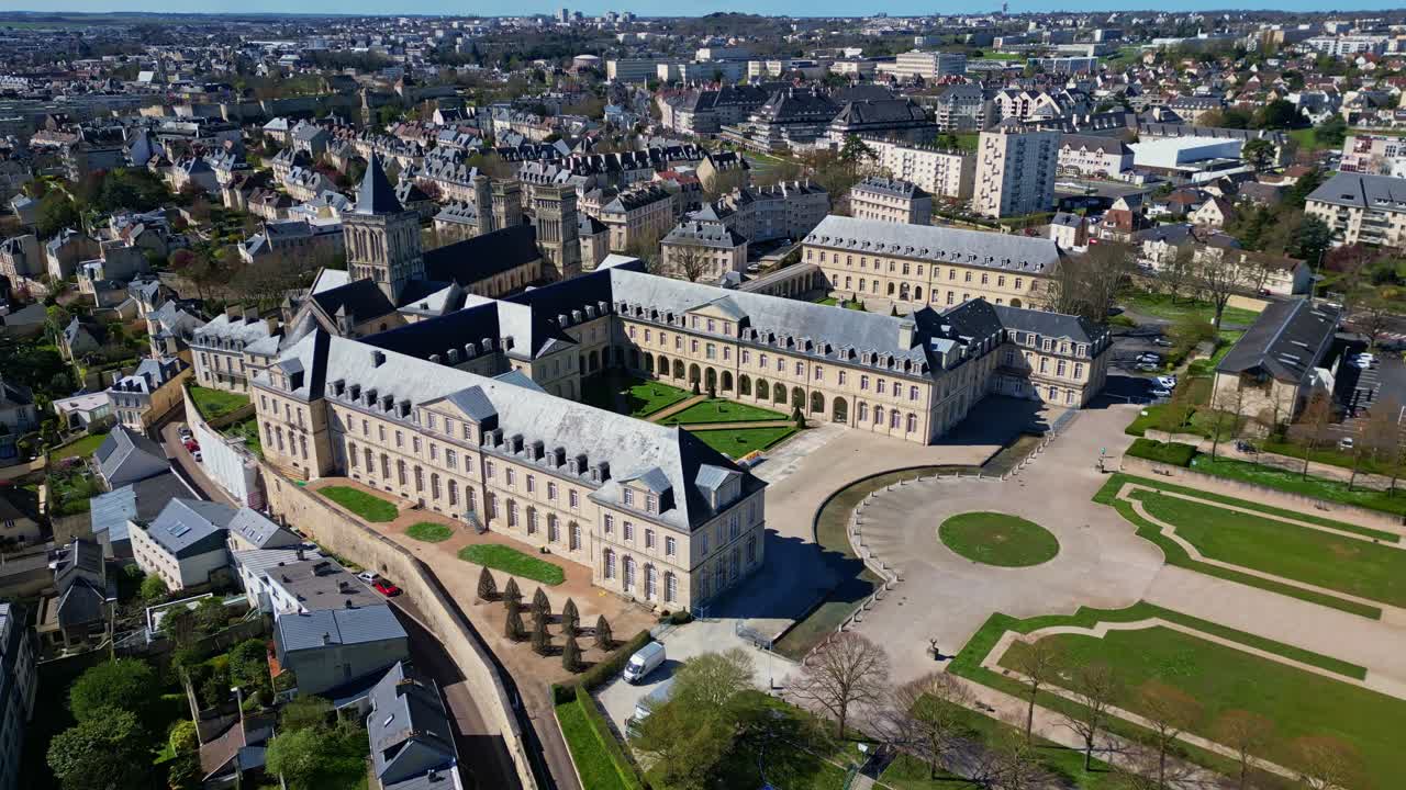 Abbaye aux Dames or Abbey women at Caen, gardens and park, Normandy in France. Aerial drone backward and cityscape