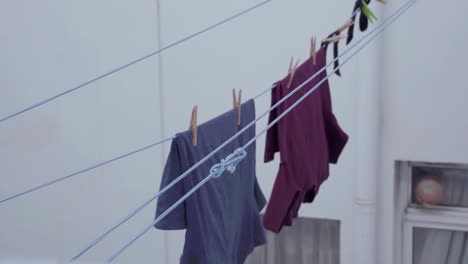 t-shirts left hanging on ropes to dry after washing in slow motion - medium tripod shot