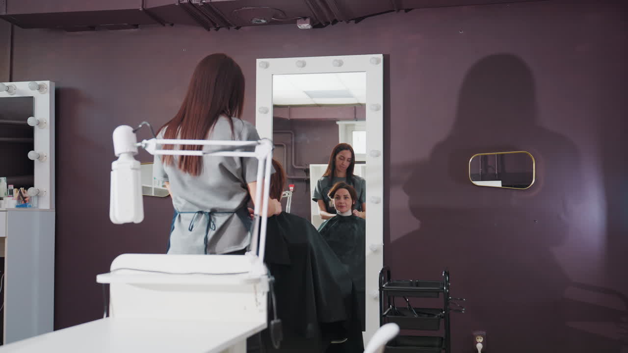 스타일리스트가 작업대를 준비하고, 미용실 주인이 작업 공간을 정리하며, 뷰티 전문가가 도구를 정돈하고 거울을 확인하고, 헤어 디자이너가 작업대를 정리하고 거울에 비친 모습을 꼼꼼히 살펴봐요.