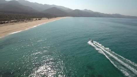 Follow-Drone-Aerial-Footage-of-speedboat-cruising-along-ocean-at-Cabo-San-Lucas,-Mexico