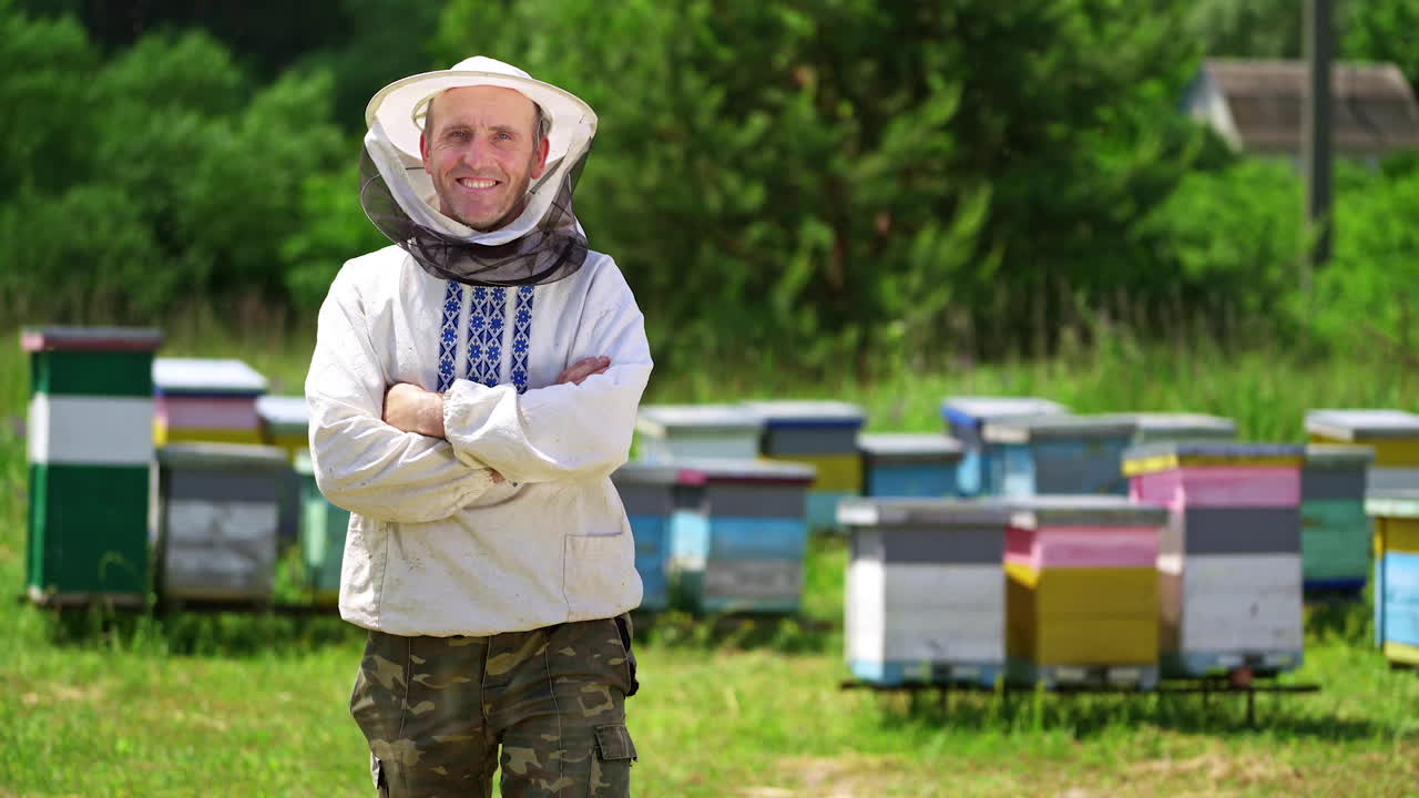 Beekeeper on a farm. Half-length portrait of male apiarist in a protective hat on the background of apiary. Production of natural product. Apiary concept.