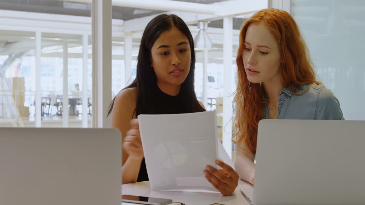 Executives discussing over laptop and document 4k