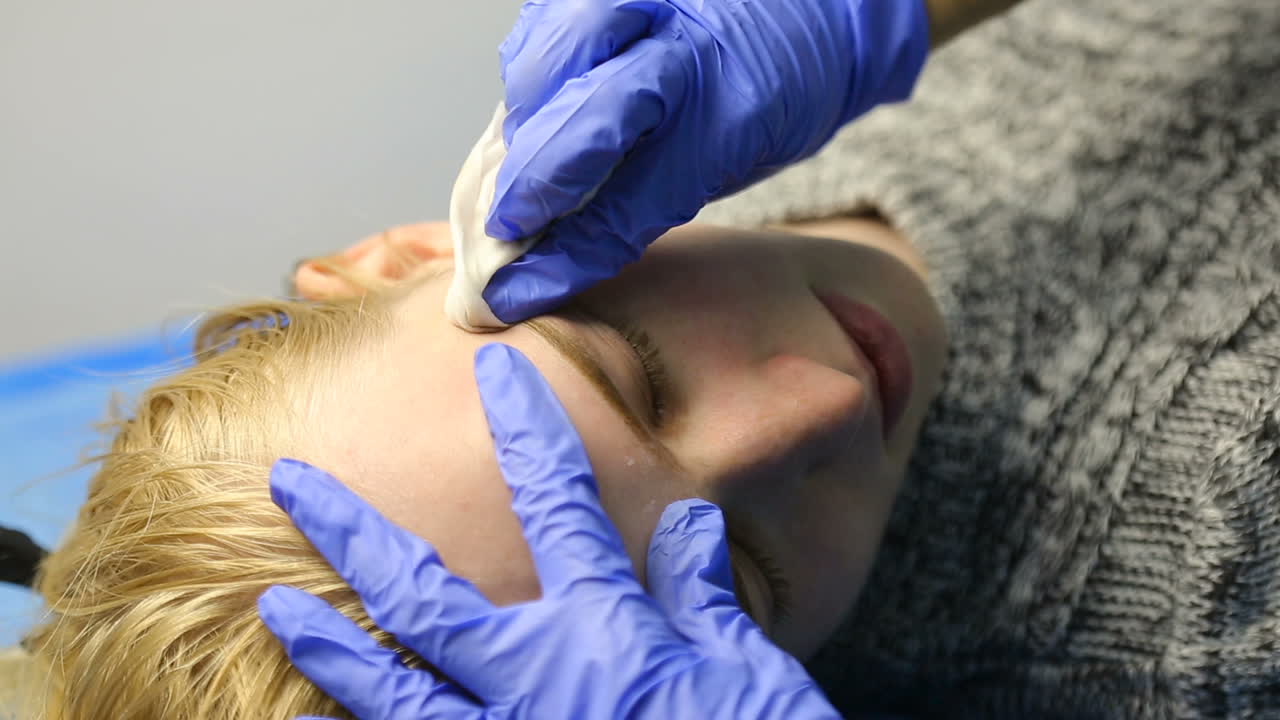 Professional tattooist making eyebrow make up