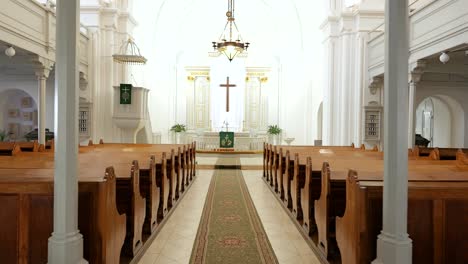 Dolly-forward-down-aisle-past-empty-wooden-pews-in-Lutheran-church-sanctuary