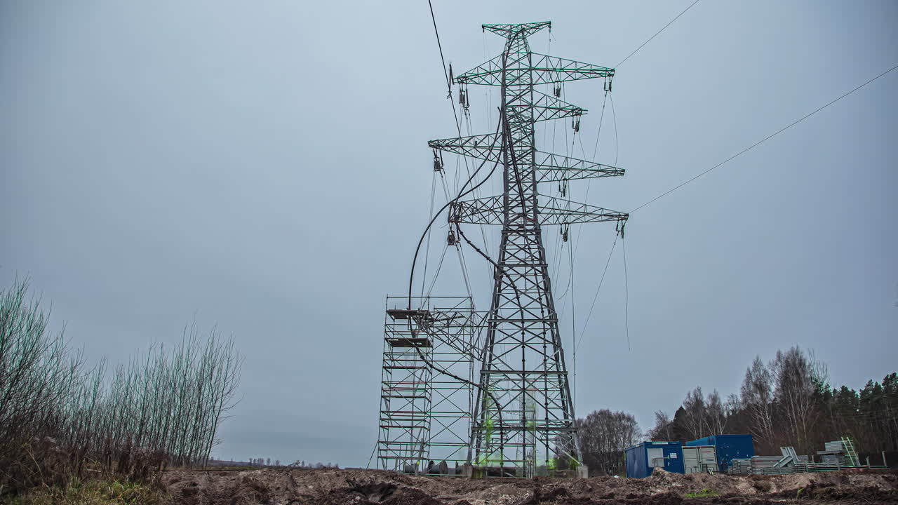 Low angle shot of utility workers climbing up high electrical pole before placing power lines in rural countryside at daytime