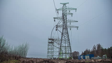 Low-angle-shot-of-utility-workers-climbing-up-high-electrical-pole-before-placing-power-lines-in-rural-countryside-at-daytime