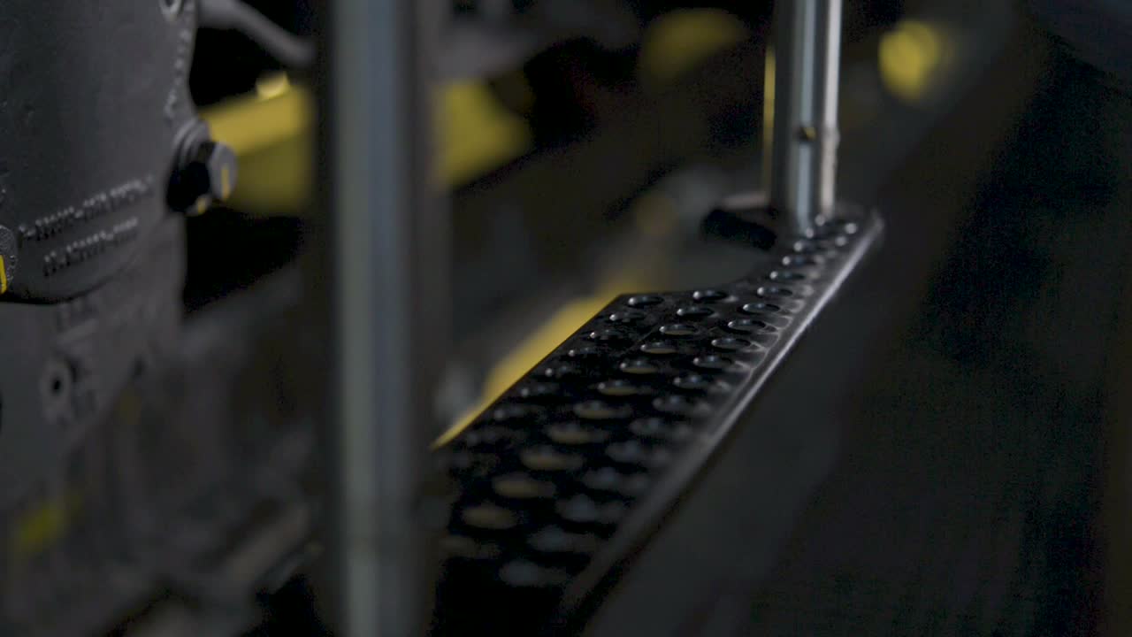 primer plano de una bota pisando una superficie metálica dentro de un entorno industrial