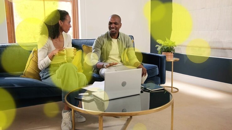 Woman reaching laptop, man adjusting trackpad, both checking business data with animated chart