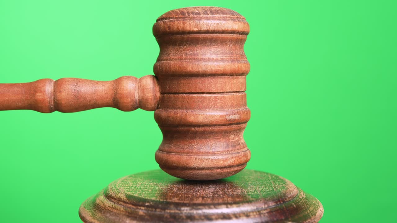 Gavel being struck to decide an auction or guilty verdict in court. Green Screen. Medium and wide shot with Black and white Alpha included.