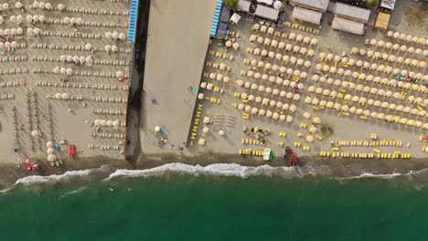 Una-Concurrida-Playa-Con-Sombrillas-En-Liguria,-Italia-Durante-El-Verano,-Vista-Aérea