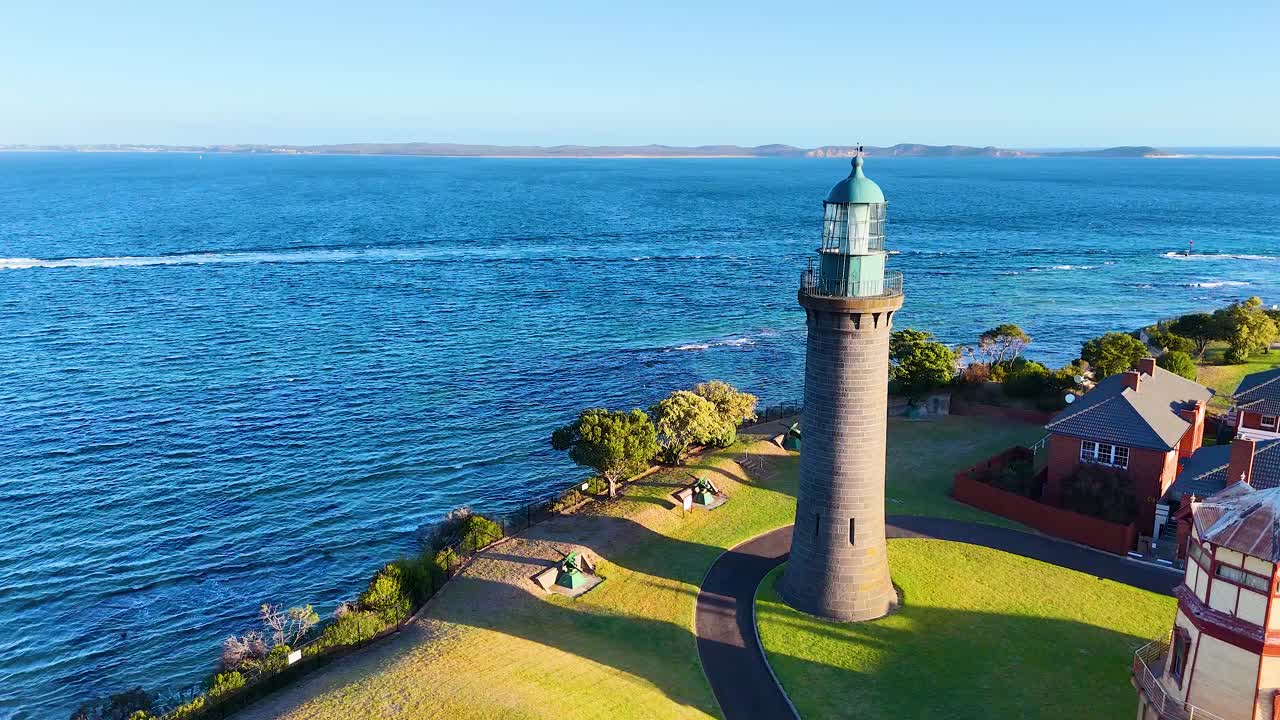 Aerial footage of Queenscliff Lighthouse on Bellarine Peninsula, showcasing the coastal landscape and serene ocean under bright daylight