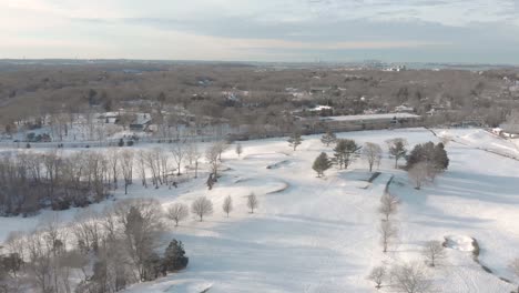 gentle and slow drone aerial toward boston in the distance, over a snowy golf course