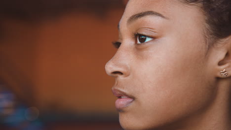 close up of a young woman's face looking to side with a focused and determined expression