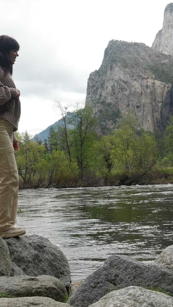 Woman Standing by River Enjoying Scenic Yosemite Waterfall and Mountain View