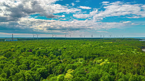 Wind-Turbines-Towering-Over-Lush-Forests-By-The-Shoreline