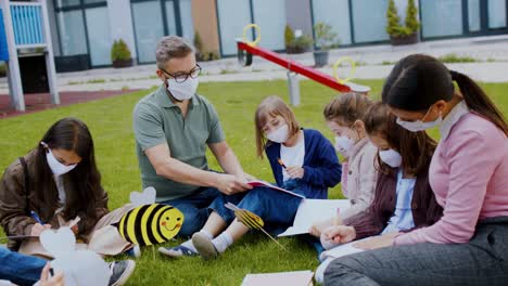 group of cheerful children learning outdoors at school after covid-19 quarantine and lockdown.