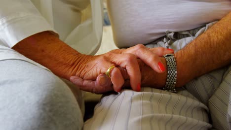 primer plano de una pareja de ancianos tomados de la mano en el dormitorio de una casa cómoda 4k