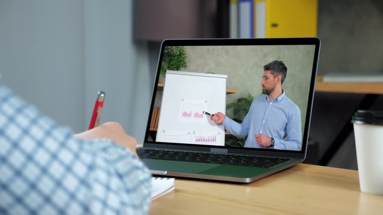 Man study online business webinar laptop, writes in notebook listen teacher