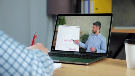 hombre de estudio en línea de negocios webinar portátil, escribe en el cuaderno escuchar maestro