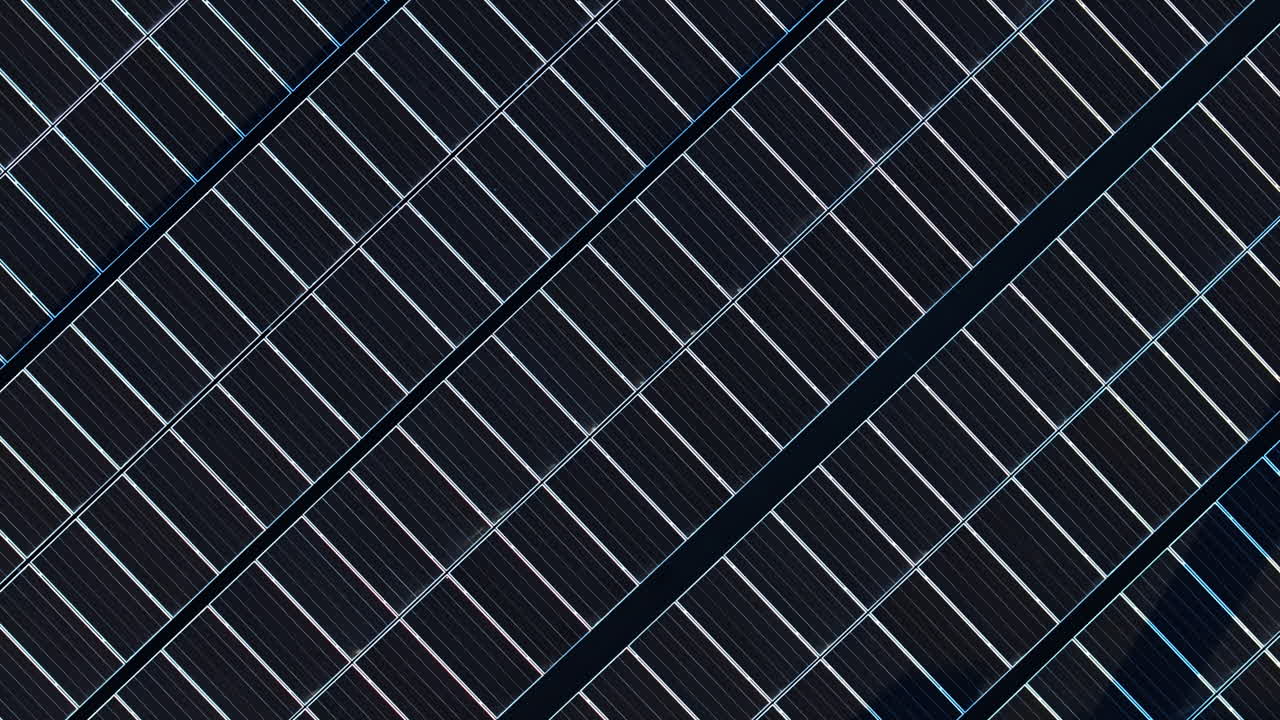 Aerial drone view of solar panels at sunset. Photovoltaics on top of the roof of the building. Alternative electricity source. Concept of sustainable resources