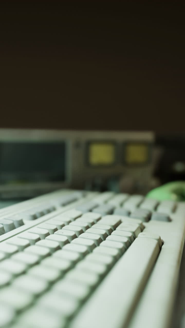 Old computer keyboard and equipment in a workspace during night hours