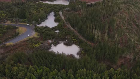 The-Boiling-Mud-Pool-At-Wai-O-Tapu-In-Rotorua,-New-Zealand,-Remains-Of-An-Eroded-Mud-Volcano---aerial-drone-shot