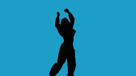 studio silhouette of woman dancing against blue background