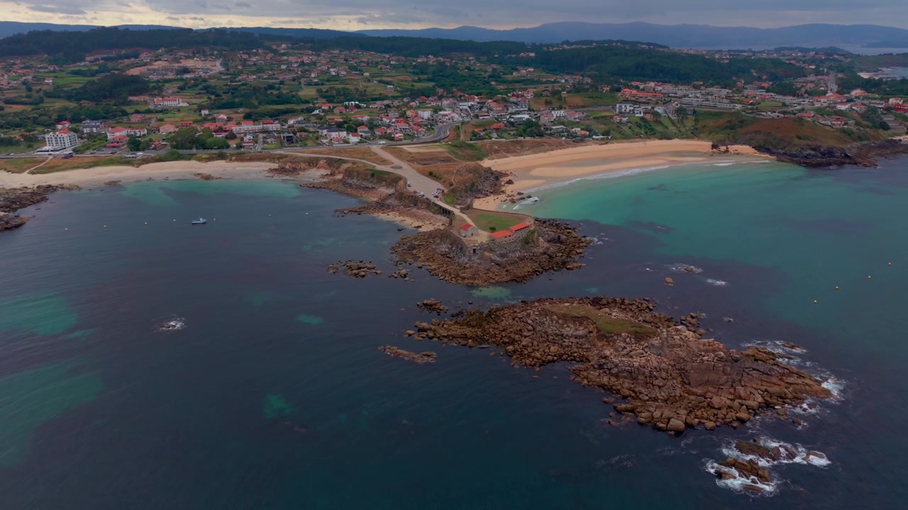 Luftfoto - Capela de Nosa Señora da Lanzada på en klippefremspring mellem to sandstrande i Galicien