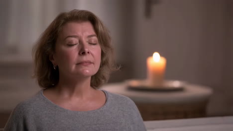 woman meditating by candlelight