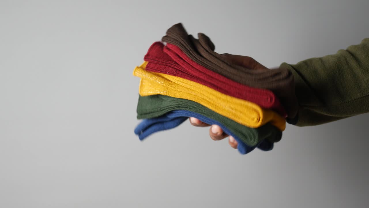 Hand holding a stack of colorful socks
