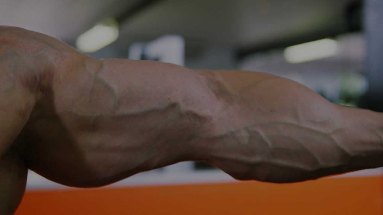 Male athlete flexing arm as camera pulling back causing transparent finance charts showing trends