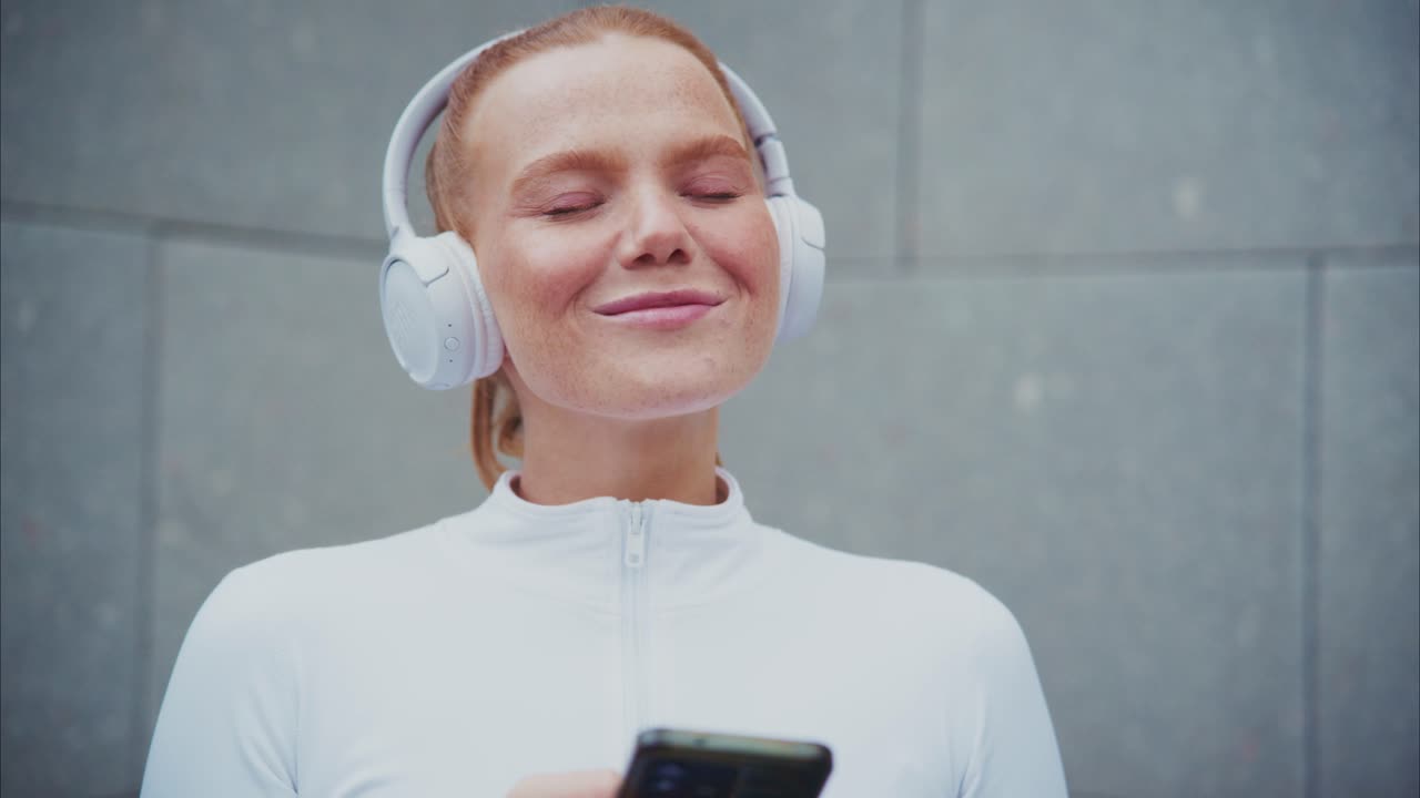 Woman listening to music on headphones with smartphone