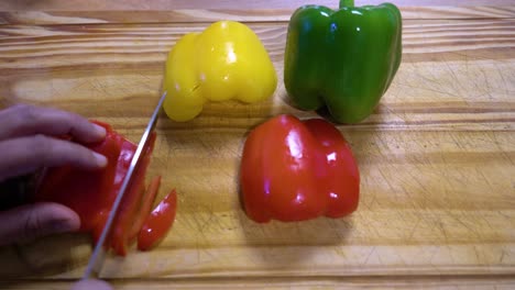 rebanar pimientos en juliana sobre tablero de madera cocina dieta sana y saludable