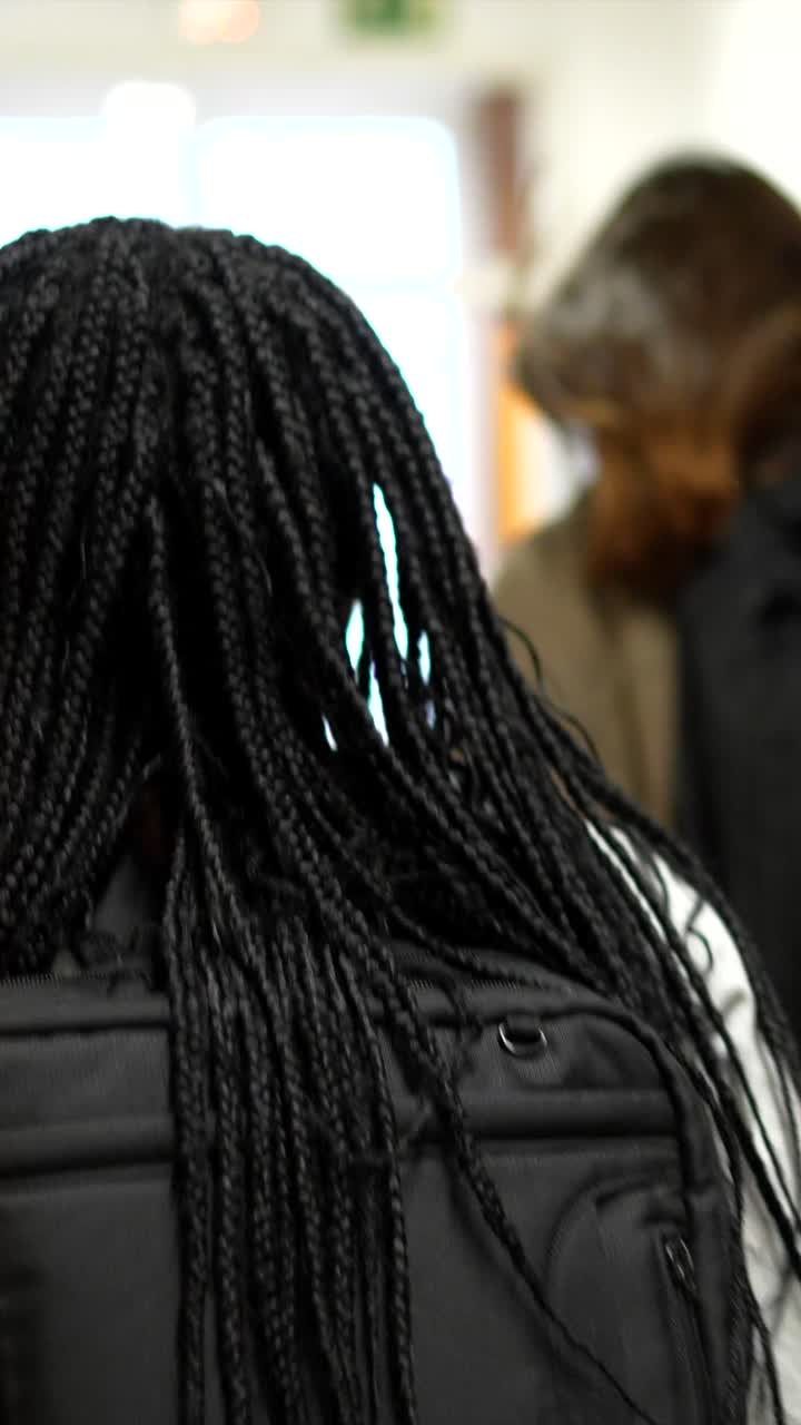 Students walking with backpacks in a school hallway