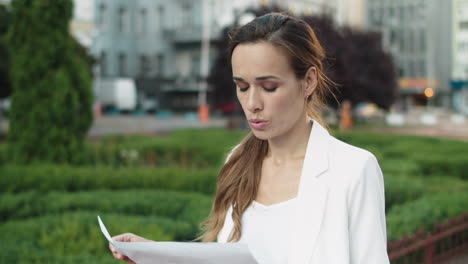 mujer de negocios pensativa buscando datos en el papeleo