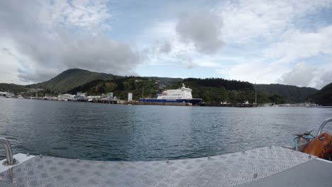 a shot of the bluebridge ferry in picton, nz from the side of a smaller boat.