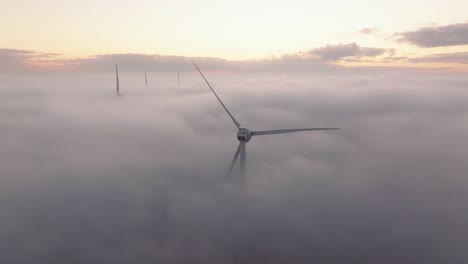 drone shot of a windturbine in foggy conditions