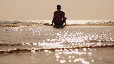 Silhouette-Of-A-Young-Man-Sitting-On-A-Small-Sand-Island
