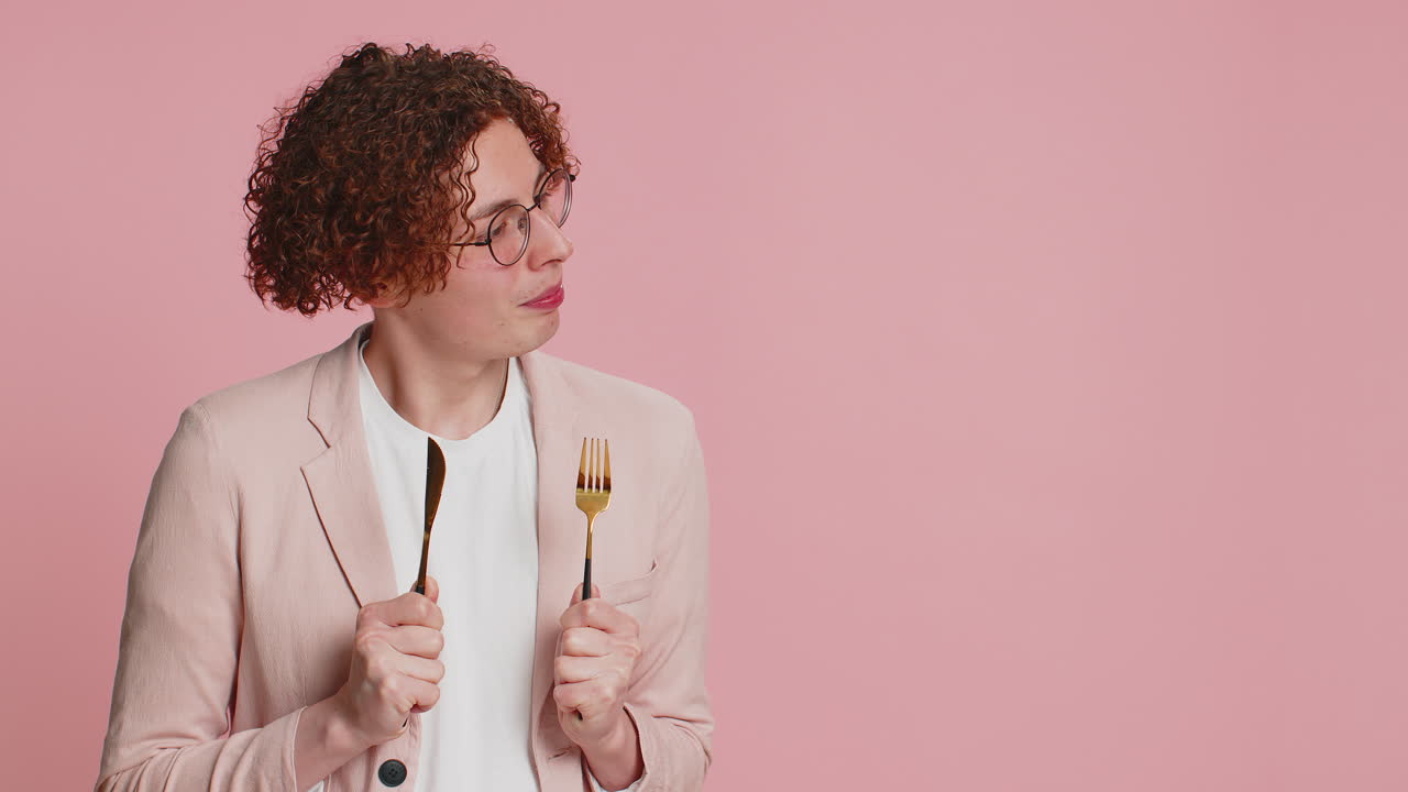 ⁇ 주린 남자가 저녁 식사를 위해 기다리고 있습니다. 불안함으로 식사 접시를 들고 식기 포크 칼을 들고 있습니다.