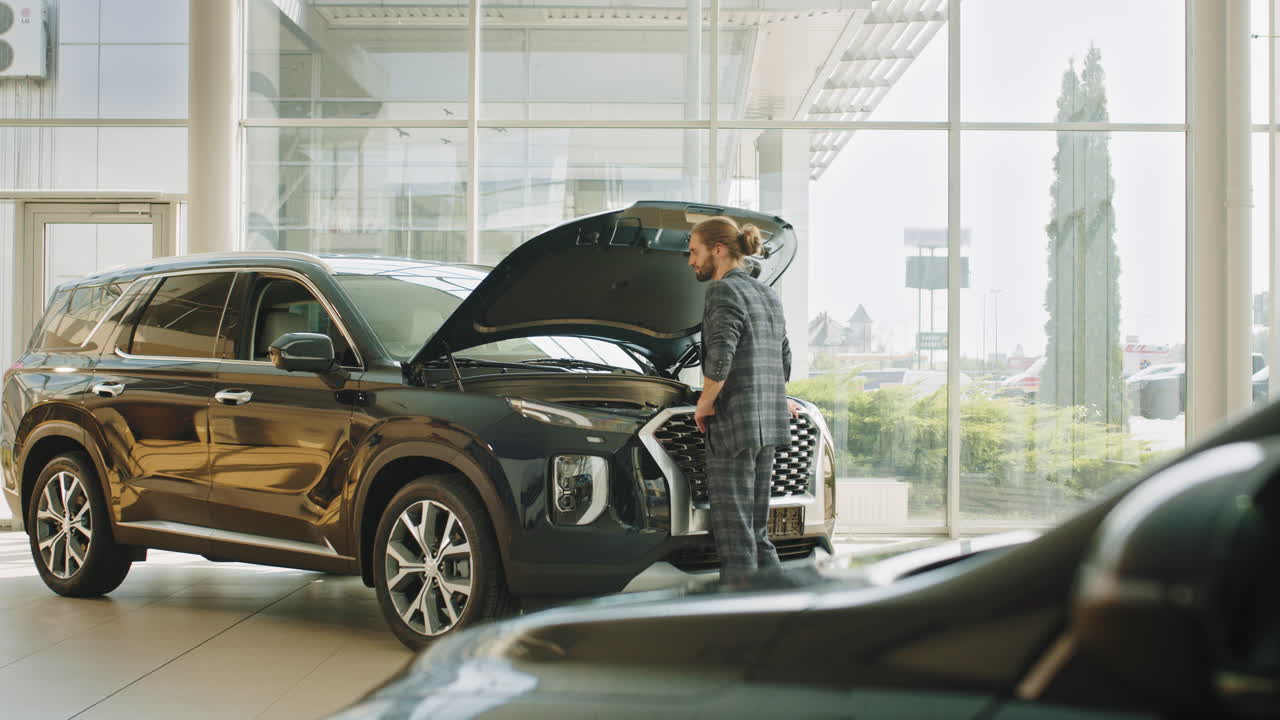 hombre inspeccionando un coche en una sala de exposiciones