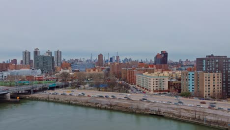 4K-drone-descending-shot-of-New-York-City,-Harlem-skyline-and-highway,-day